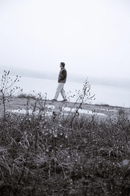 Black-and-white distant figure on the lakeshore