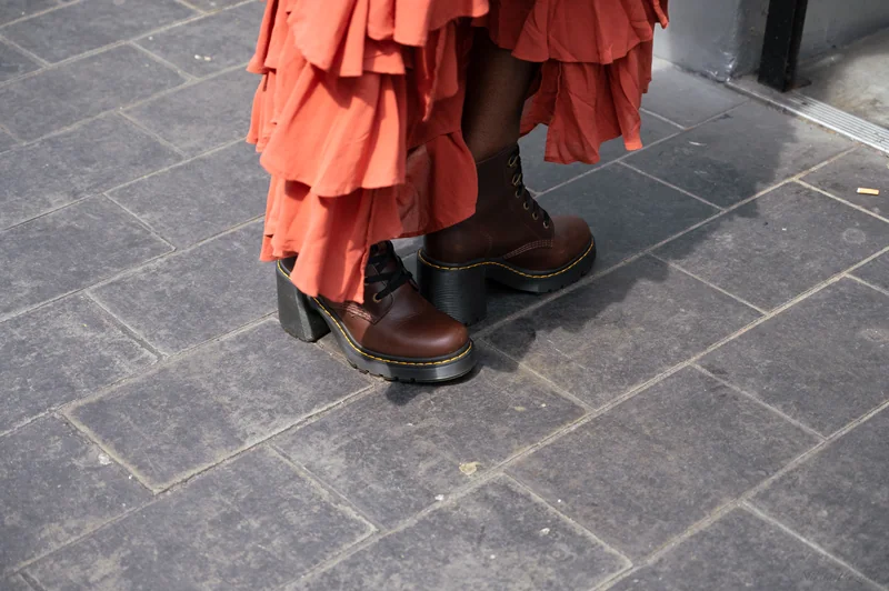 Brown platform boots and an orange dress hem on London paving