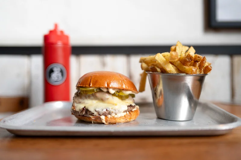 Burger and fries on a metal tray at Patty and Bun