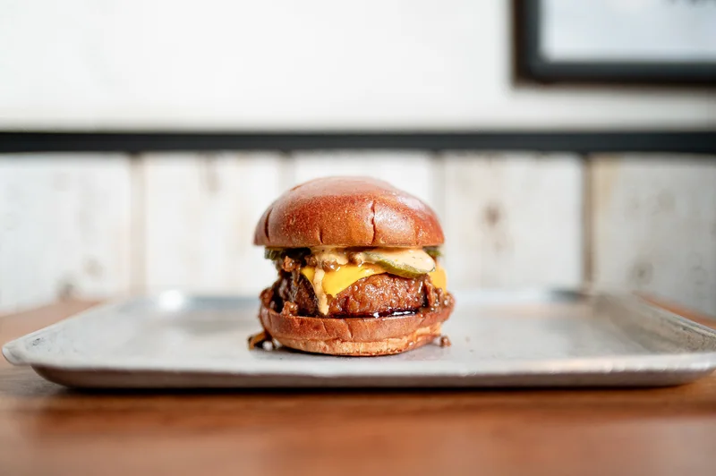 Burger centred on a paper-lined metal tray