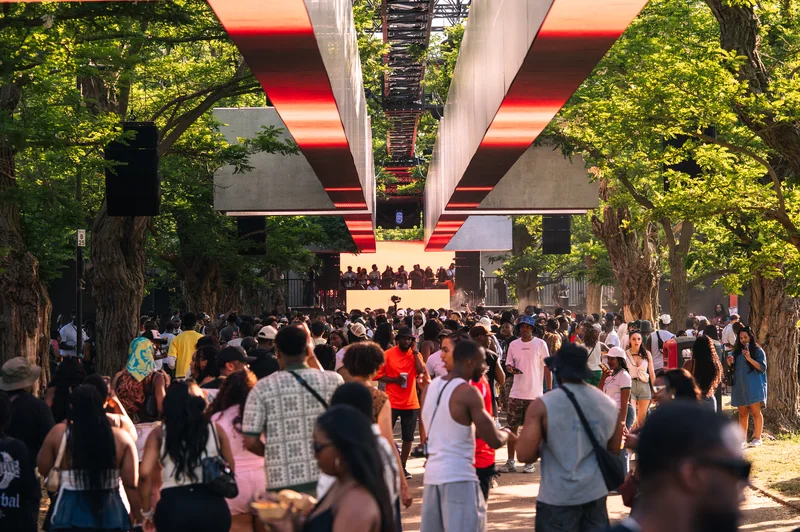 Crowd beneath mirrored ribbons at Highlights outdoor festival