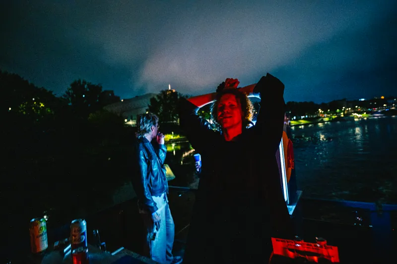 Guest under red light against the blue night during the District boat event in Vilnius