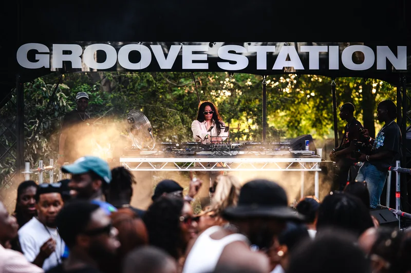 DJ on the Groove Station stage above the festival crowd