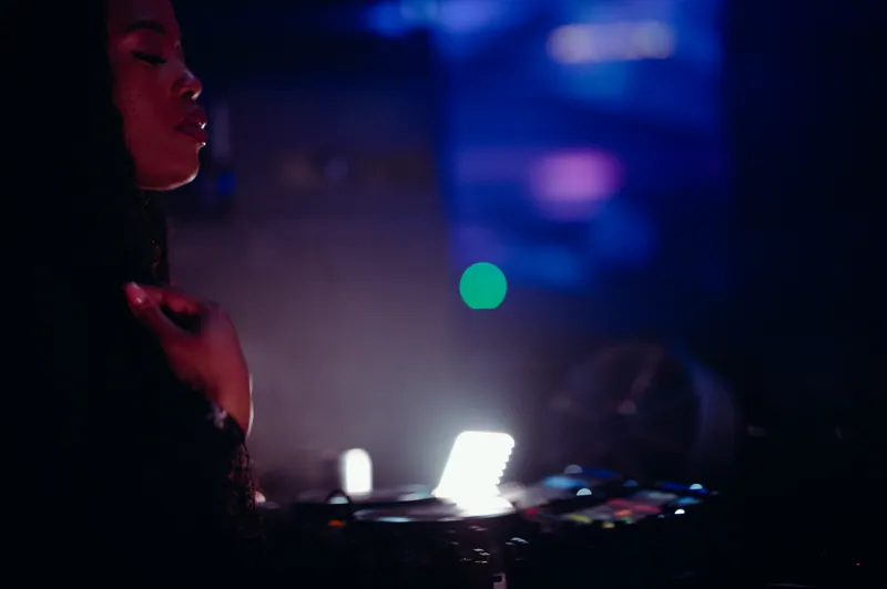 DJ in profile beside the decks under blue light at 77 London