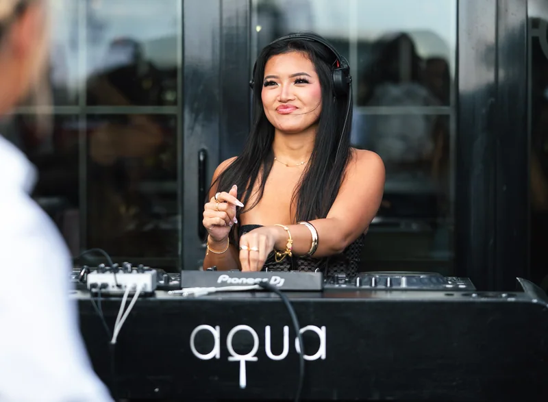 DJ wearing headphones at the Aqua Nueva mixer in daylight