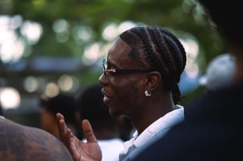 Festival guest in profile with braided hair and sunglasses