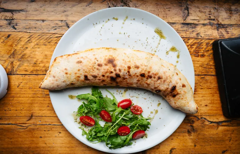 Folded calzone served with salad at Bocca in Cielo