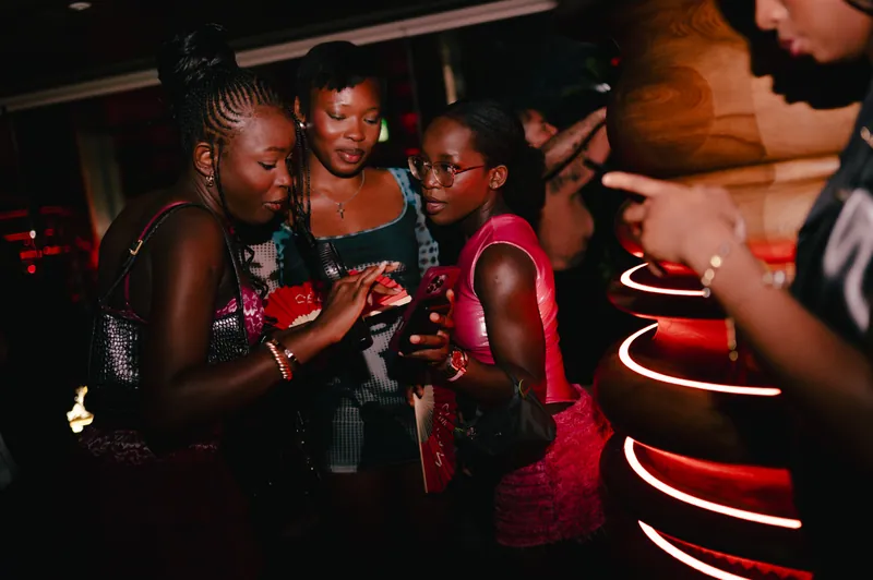 Friends sharing a moment around a phone at CE LA VI