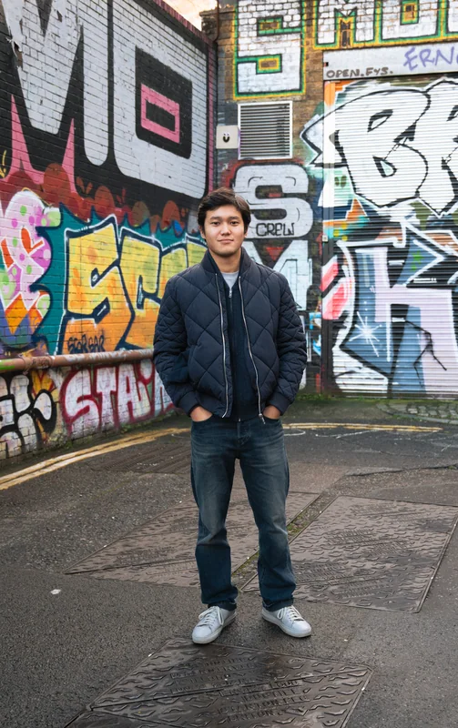 Full-length portrait against a colourful mural