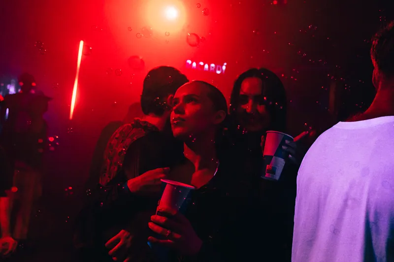 Two guests together in red light and bubbles at Gallery 1986