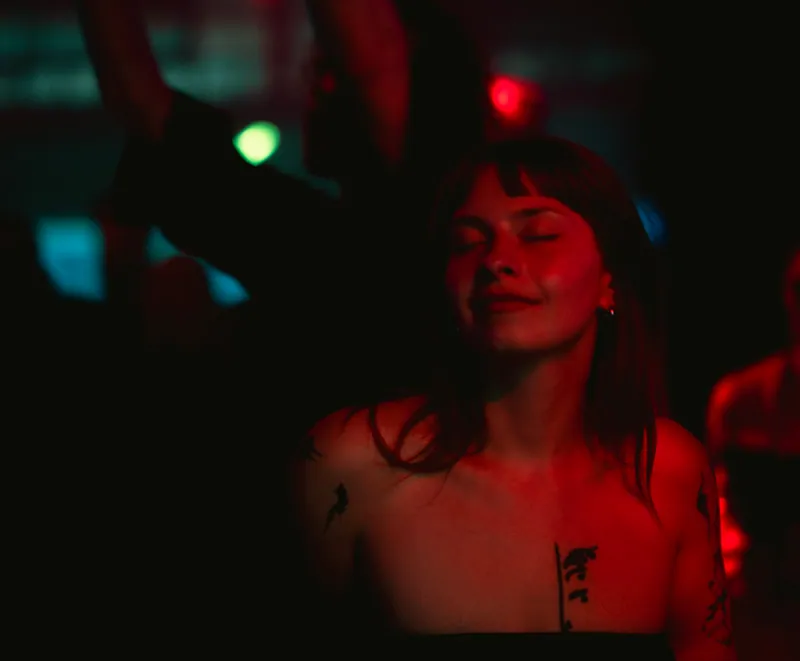 Guest immersed in the music and warm red light at Gallery 1986