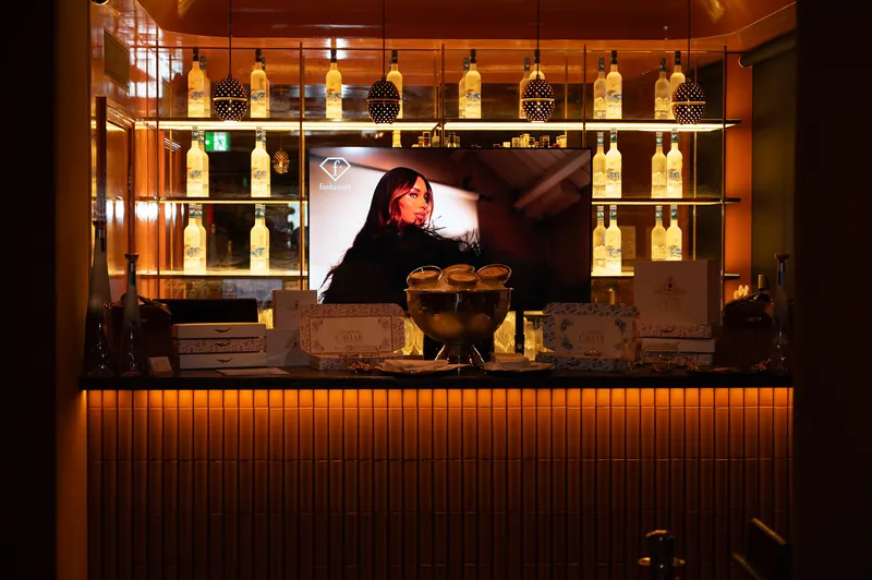 Golden-lit bar and FashionTV screen set the atmosphere for the event