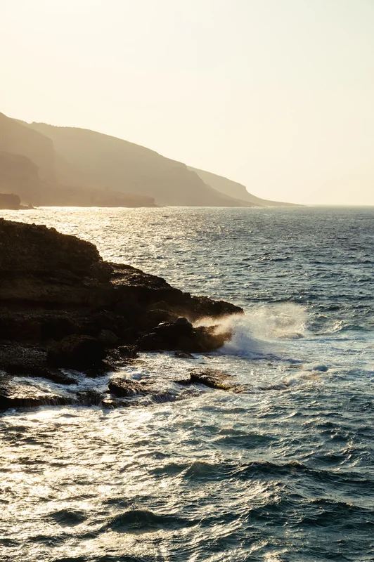 Golden evening light on waves breaking along the Greek coastline
