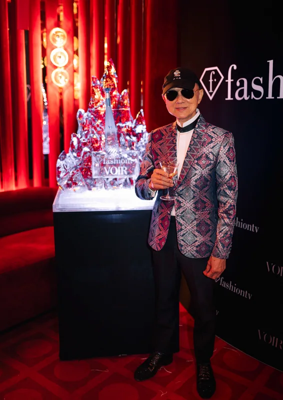 Guest in a patterned jacket beside the FashionTV backdrop