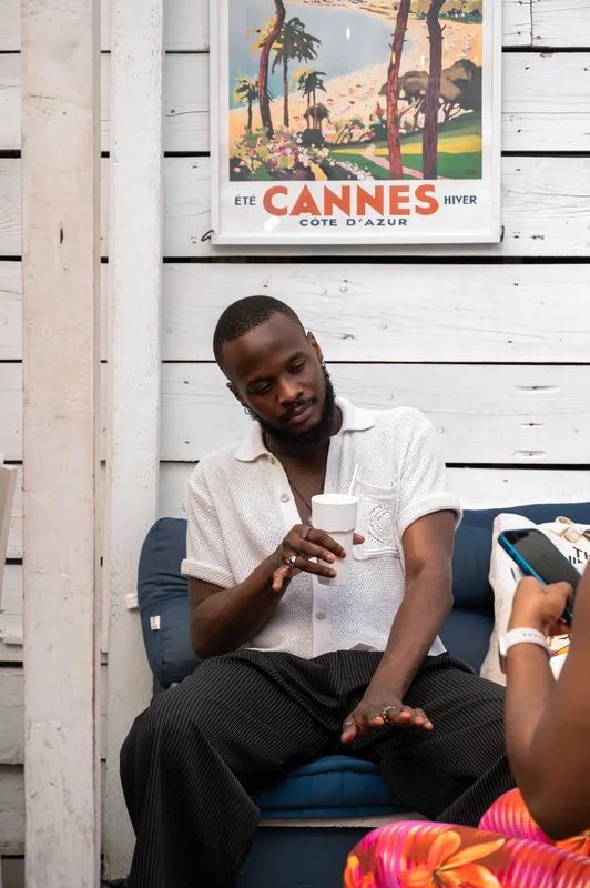 Guest in a white polo seated beneath a Cannes poster at Bubba Oasis
