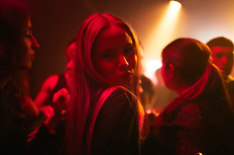 Guest looking back beneath red and amber club lighting