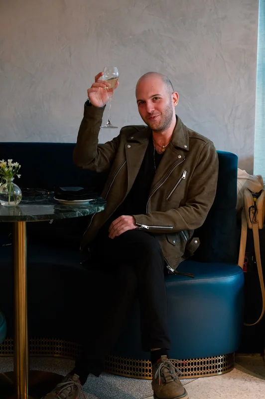 Guest raising a glass from a blue lounge chair