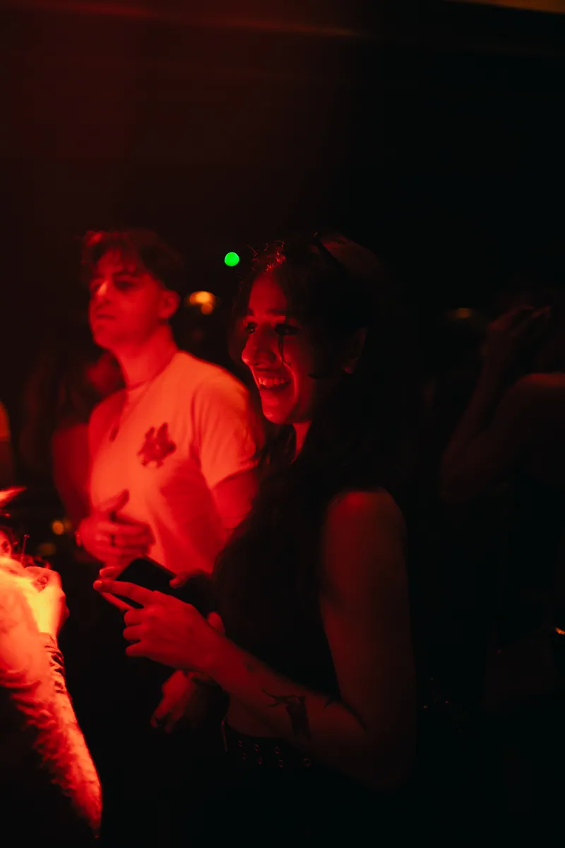 Guest smiling in the red light at 77 London