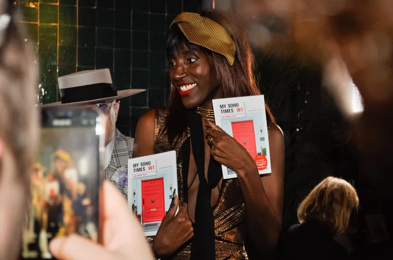Guest smiling with copies of the magazine