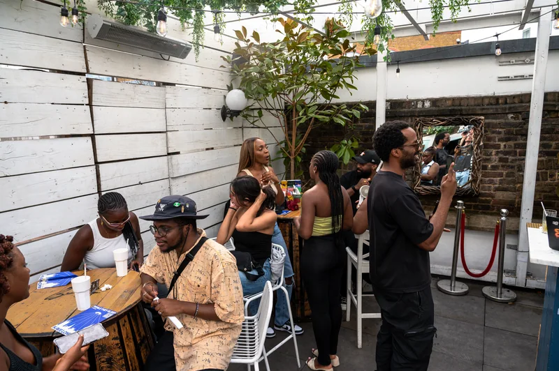Guests chatting around a table on the Bubba Oasis rooftop