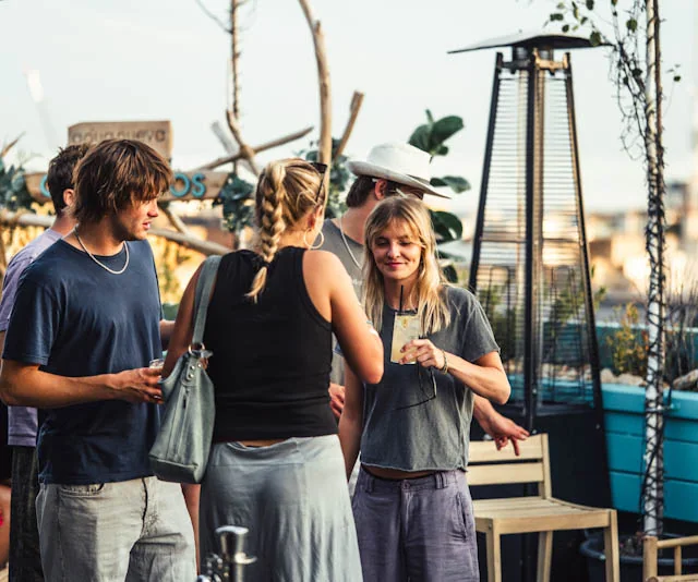 Guests chatting on the rooftop terrace at sunset