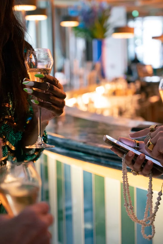 Hands and drinks reflected in the polished BoTree bar