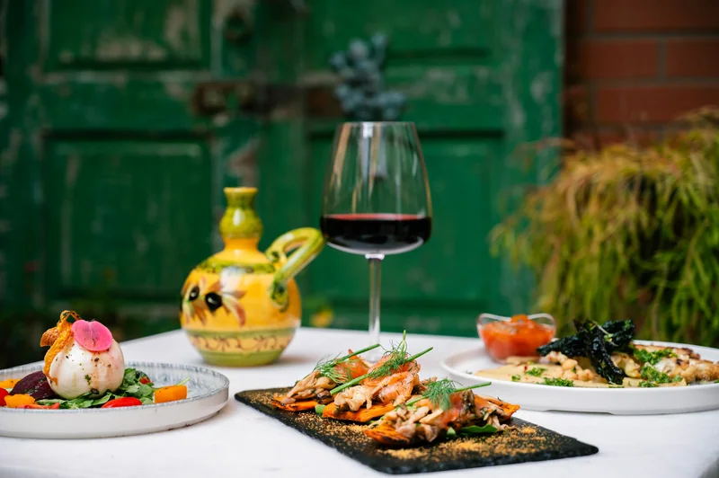 Italian dishes and red wine on an outdoor table