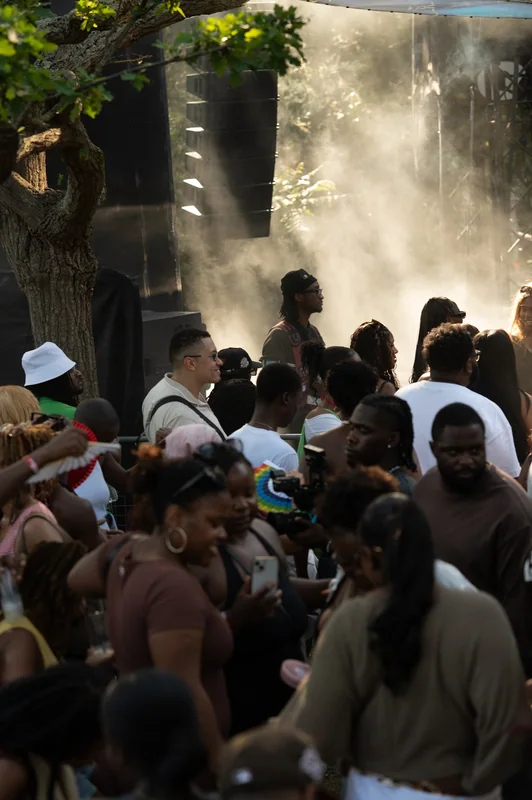 Layers of people beneath shafts of light and haze at Highlights.