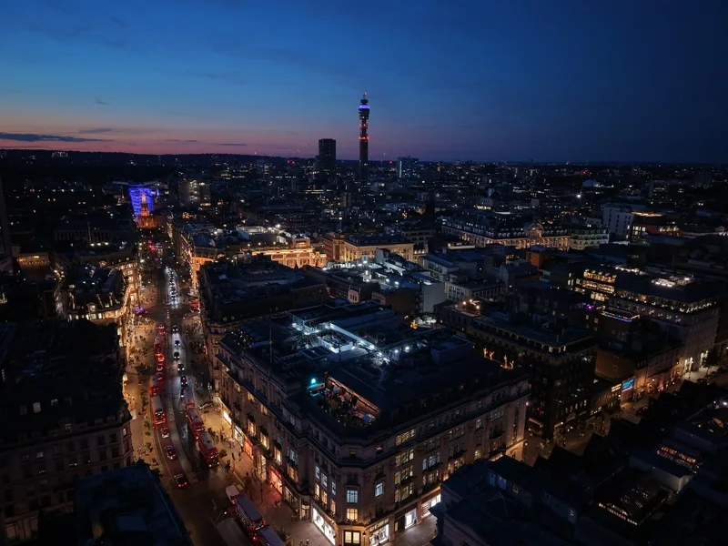 London rooftops and illuminated streets beneath a blue-hour sky