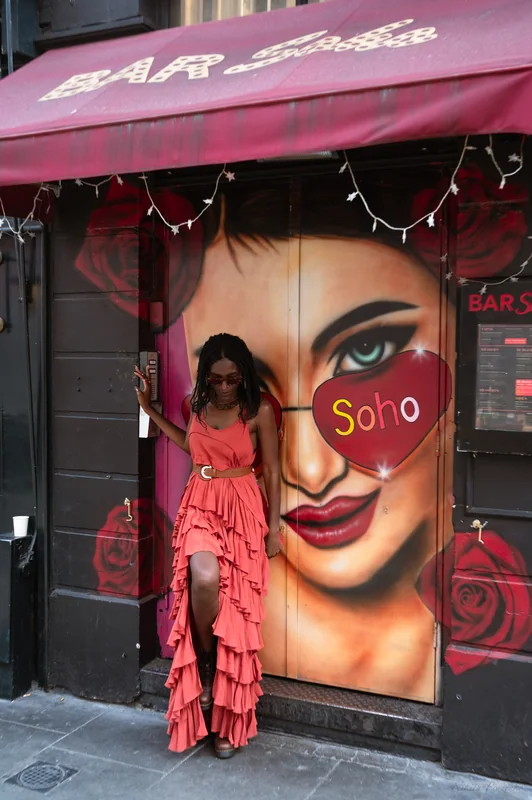 Orange dress portrait against a colourful graphic Soho wall