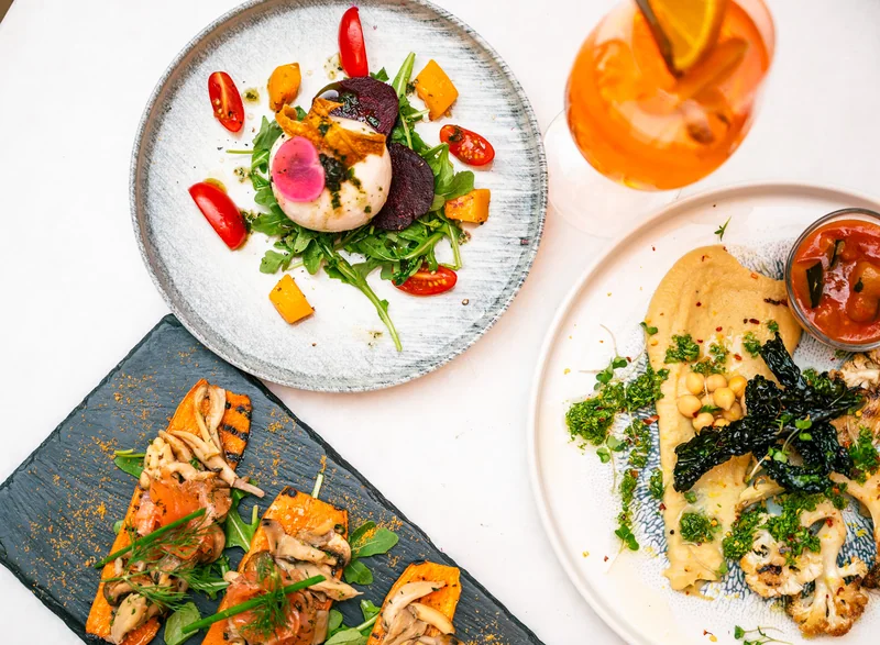 Colourful overhead arrangement of Italian dishes and a drink