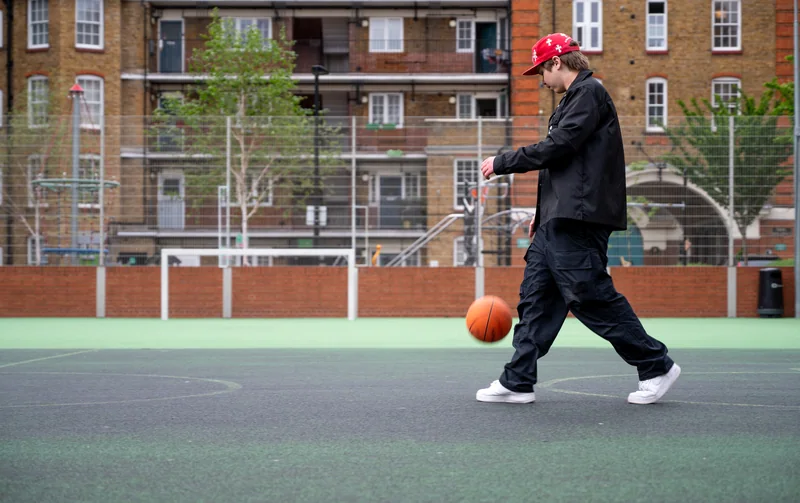 Player dribbling across a green outdoor basketball court