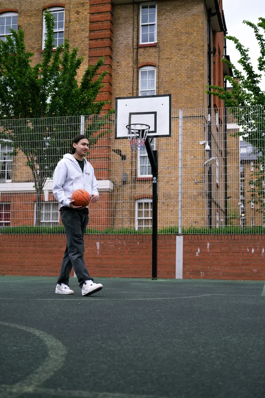 Player holding a basketball beneath the hoop