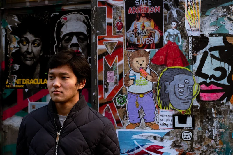 Portrait against a wall of posters and street art