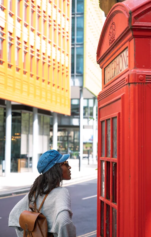 Portrait in a blue cap beside a red London telephone box