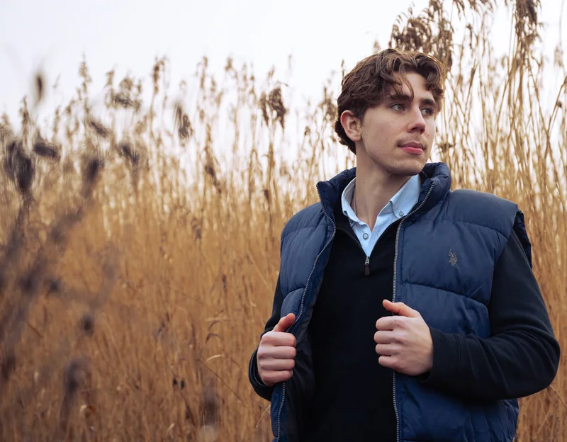 Portrait in a dark jacket against tall reeds