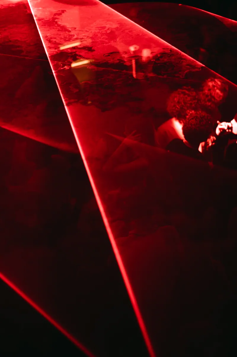Red reflections and a guest behind glass at 77 London