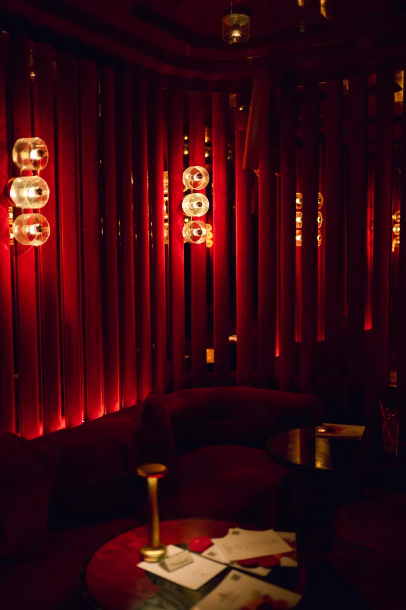 Red velvet seating and sculptural glass lights inside the FashionTV venue
