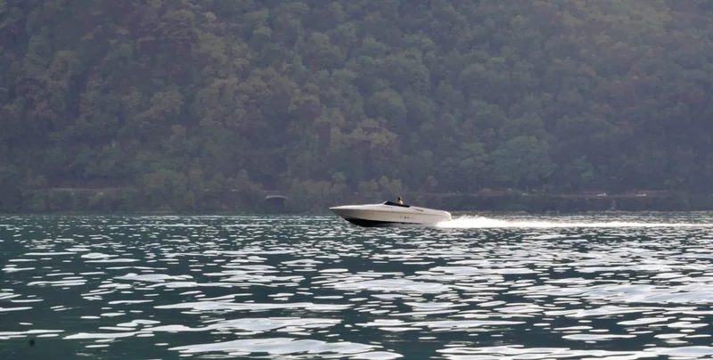Speedboat punctuates a spare lake and mountain composition