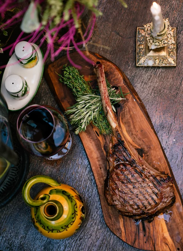 Steak on a wooden board with herbs and sauces