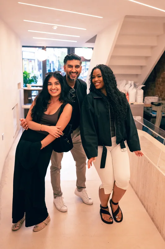 Three guests smiling together inside the COODIE café
