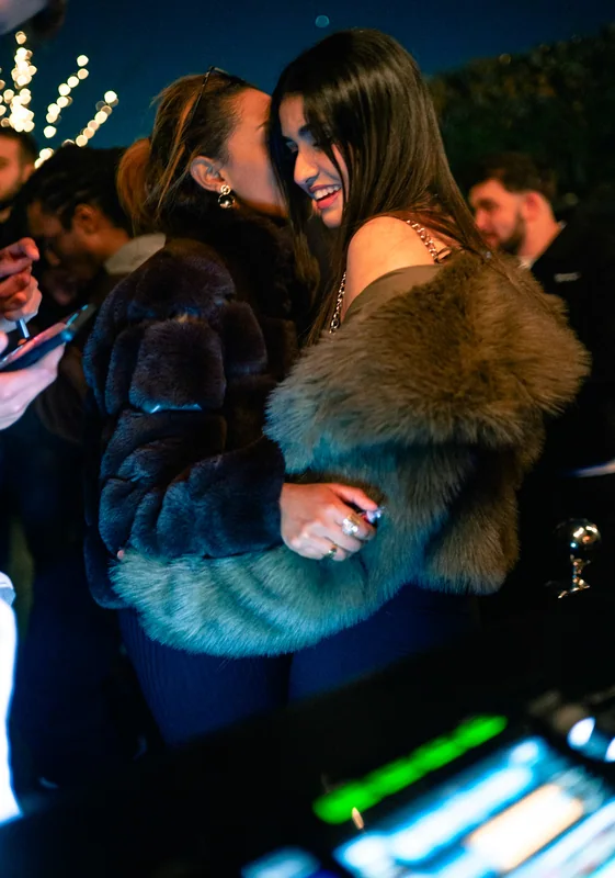 Two guests embracing beside the DJ booth
