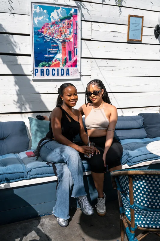 Two guests posing on a sunlit bench at Bubba Oasis