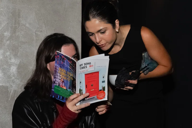 Two guests reading My Soho Times together