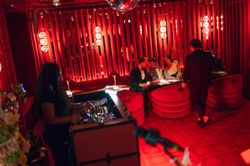 View past the DJ towards guests seated in the red FashionTV lounge