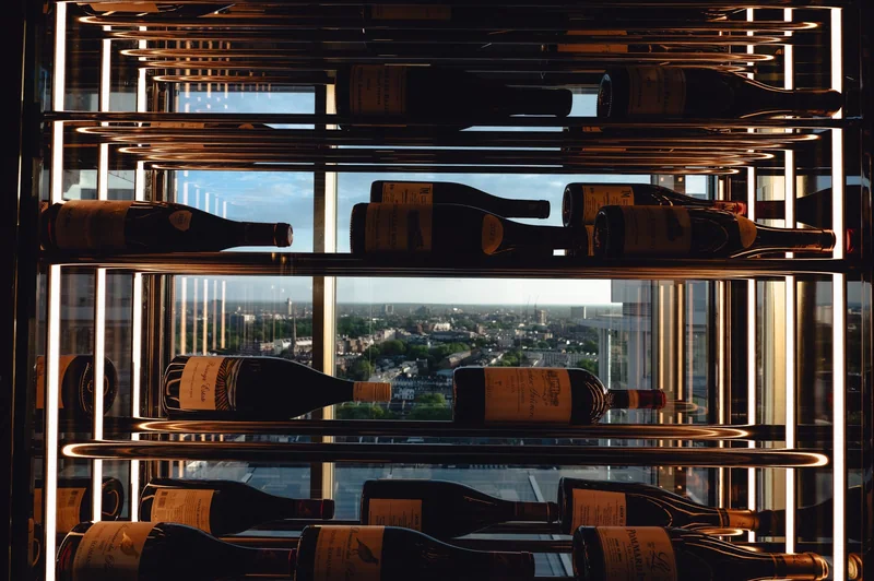 Wine shelving frames the city view through warm geometric lines.